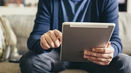 Man sitting on couch using a tablet