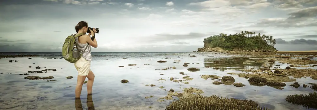 LASIK for photographers, female photographer taking a photo of an island