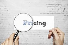man holding a piece of paper with the word pricing on it while holding magnifying glass