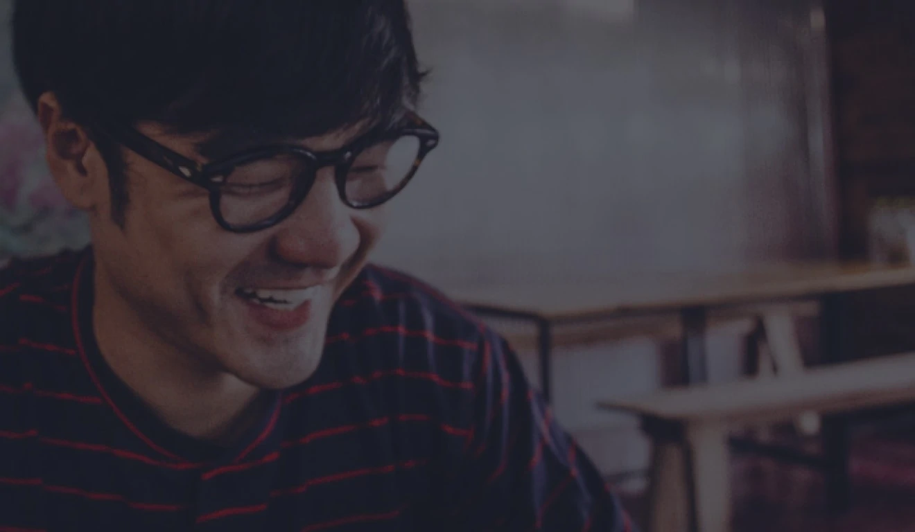 Man wearing black glasses and smiling